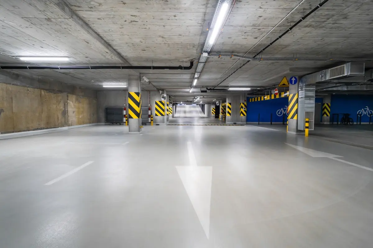 Parking garage floor with a painted directional arrow and lane lines
